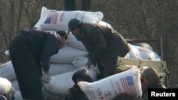 Para pekerja menurunkan bantuan makanan dari sebuah truk di wilayah Sinuiju, Korea Utara, 11 Desember 2008. (Foto: Reuters/dok)