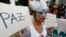 FILE - A demonstrator holds a sign reading "Peace" during a march in Bogota, Nov. 19, 2014.