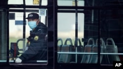 A security guard wearing a mask rides on an empty bus in Beijing, Sunday, Feb. 9, 2020. China's virus death toll on Sunday have surpassed the number of fatalities in the 2002-2003 SARS epidemic, but fewer new cases were reported in a possible sign…