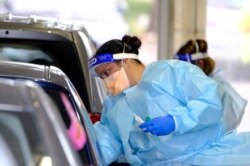 A health worker administers a test for the coronavirus disease as the city experiences a new cluster of cases in Melbourne, Australia, May 25, 2021.