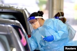 A health worker administers a test for the coronavirus disease as the city experiences a new cluster of cases in Melbourne, Australia, May 25, 2021.