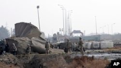 Pasukan AS memerikasa lokasi pasca serangan bom bunuh diri dekat gerbang NATO di Kabul, Afghanistan (11/12).