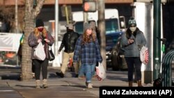 Para konsumen mengenakan masker wajah sambil berbelanja di Denver Pavilions, Selasa, 29 Desember 2020. (Foto: AP)