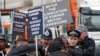 FILE - Police officers apprehend protesters demonstrating against the government of Cameroon outside of the annual Commonwealth Day service at Westminster Abbey in London, March 9, 2020. 