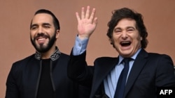 El presidente de Argentina, Javier Milei saluda junto al presidente de El Salvador, Nayib Bukele, en el balcón del palacio presidencial Casa Rosada en Buenos Aires el 30 de septiembre de 2024.