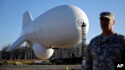 FILE - U.S. Air Force Col. William Pitts stands in front of an unmanned blimp, part of a missile defense system, during a media preview in Middle River, Md., near the Aberdeen Proving Grounds, Dec. 17, 2014.