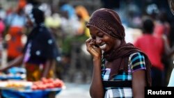 Une femme parle au téléphone dans un marché dans le quartier d'Abobo à Abidjan, en Côte d'Ivoire, le 17 avril 2011.