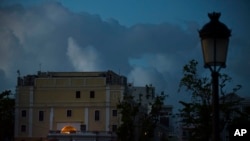 FILE - The streets of Old San Juan are dark after sunset one month after Hurricane Maria in San Juan, Puerto Rico, Oct. 20, 2017. 