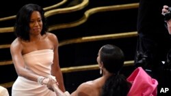 Regina King, left, and Angela Bassett shake hands in the audience prior to the start of the Oscars on Sunday, Feb. 24, 2019, at the Dolby Theatre in Los Angeles. (Photo by Chris Pizzello/Invision/AP)