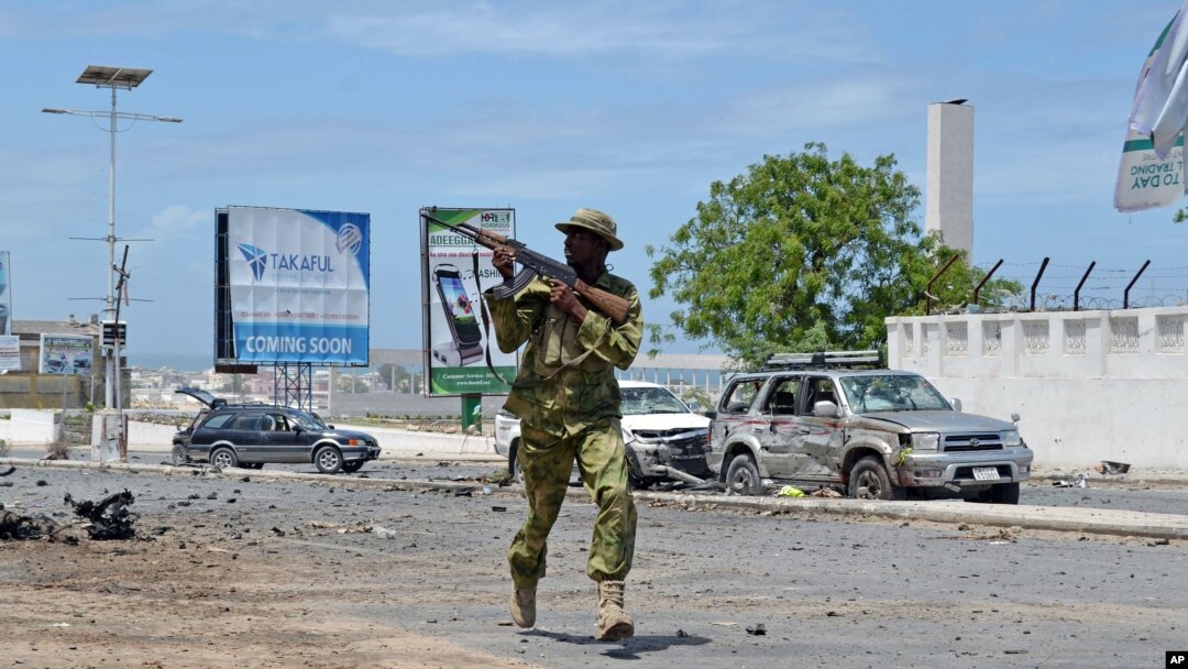 Seorang tentara Somalia berlari di tengah serangan terhadap parlemen Somalia di Mogadishu, Mei 2014. 