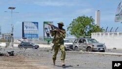 Seorang tentara Somalia berlari di tengah serangan terhadap parlemen Somalia di Mogadishu, Mei 2014. 