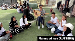 In this frame captured from video, Palestinian teenager Youssef Saad plays the oud and sings to children amid Israel-Hamas conflict, in Jabalia refugee camp in the northern Gaza Strip September 2, 2024. (REUTERS/Mahmoud Issa)