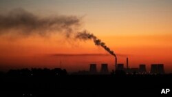 FILE - Steam comes from a coal-fired power station in Witbank, now called Emalahleni, South Africa, Oct. 11, 2021.