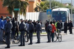 FILE - Italian police patrol as migrants from the Mineo asylum center are transferred to smaller structures after legislation passed by Italy's new government calls for its closure, near Catania in Sicily, Feb. 7, 2019.