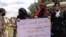 Israeli Arab women hold a sign during a protest ahead of a vote by Israel's parliament on renewing a law that bars Arab citizens of Israel from extending citizenship or even residency to spouses from the occupied West Bank and Gaza.