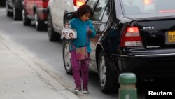 Une petite fille vend des bonbons dans une rue du quartier de Miraflores à Lima, au Pérou, le 8 août 2014.