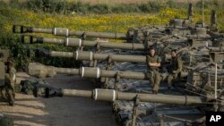 Israeli soldiers sit on top of mobile artillery near the border with Gaza, in southern Israel, March 27, 2019.