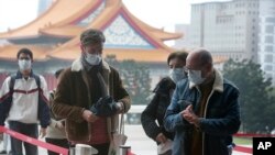 People wear face masks to protect against the spread of the coronavirus as they visit the Chiang Kai-shek Memorial Hall in Taipei, Taiwan, Thursday, Feb. 27, 2020. 
