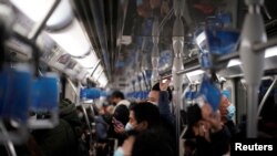 Orang-orang yang memakai masker naik kereta bawah tanah di tengah wabah COVID-19, di Shanghai, Cina, 14 Januari 2021. (Foto: REUTERS/Aly Song)