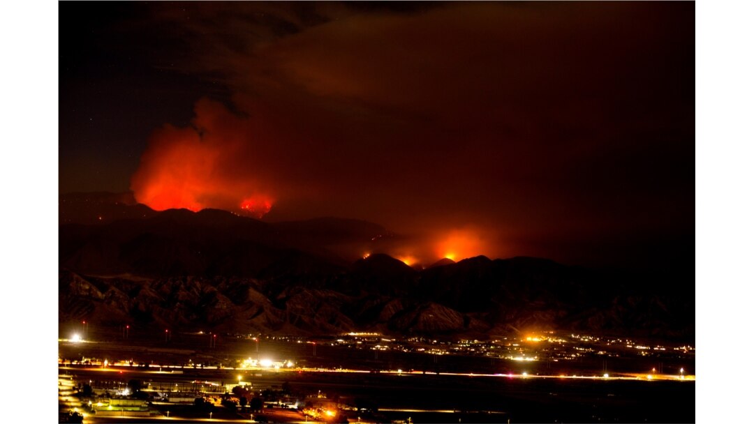 The Apple Fire burns behind mountains near Beaumont, California, August 2, 2020.
