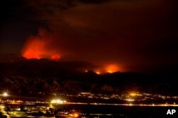The Apple Fire burns behind mountains near Beaumont, California, August 2, 2020.