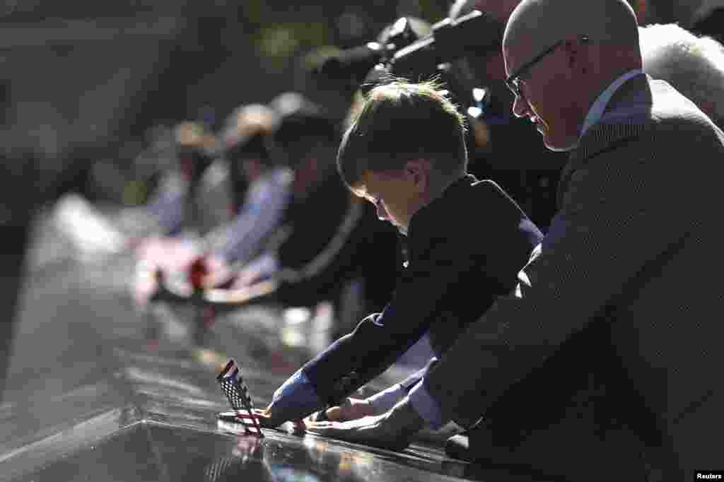 Andrew Timson, de 7 a&ntilde;os, toca el nombre de su t&iacute;o Andrew Fisher, grabado en el memorial del 9/11 que se construy&oacute; en donde estaba el World Trade Center.