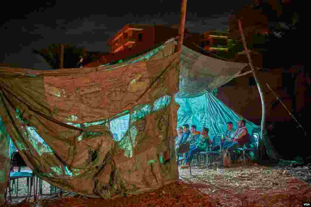 On a remote patch of barren land in the farming village of Tattay in Tanta, Egypt, bettors gather in a makeshift tent for Indian rooster fights each Thursday night. Betting and animal fights are illegal in Egypt. (H. Elrasam/VOA) 