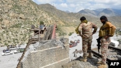 Petugas keamanan memeriksa jembatan rel kereta api yang runtuh menyusul ledakan yang dilakukan oleh militan separatis di Kolpur, distrik Bolan, provinsi Balochistan, Pakistan, pada 27 Agustus 2024. (Foto: AFP/Banaras Khan)