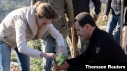 File - Syria's President Bashar al-Assad and his wife Asma, plant trees in city of Draykish, March 8, 2021.