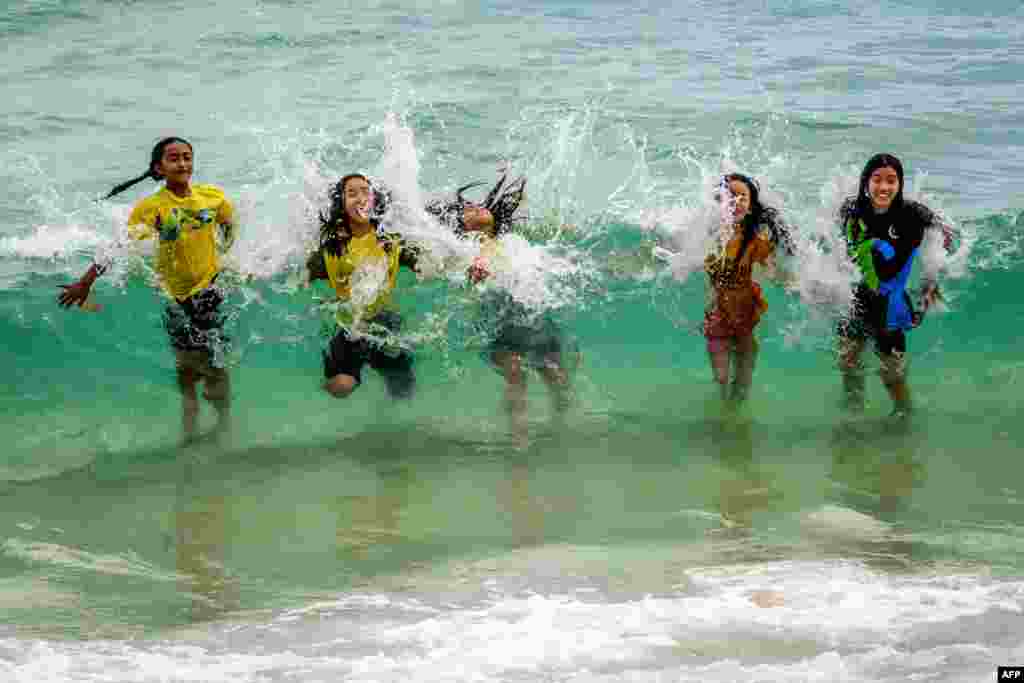 Children play in the waves on a beach in Koh Samui in the Gulf of Thailand.