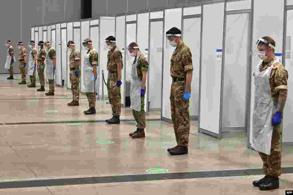 Soldiers observe a two-minute silence for Armistice Day in remembrance of the nation&#39;s war dead at a coronavirus rapid testing center in Liverpool, England.