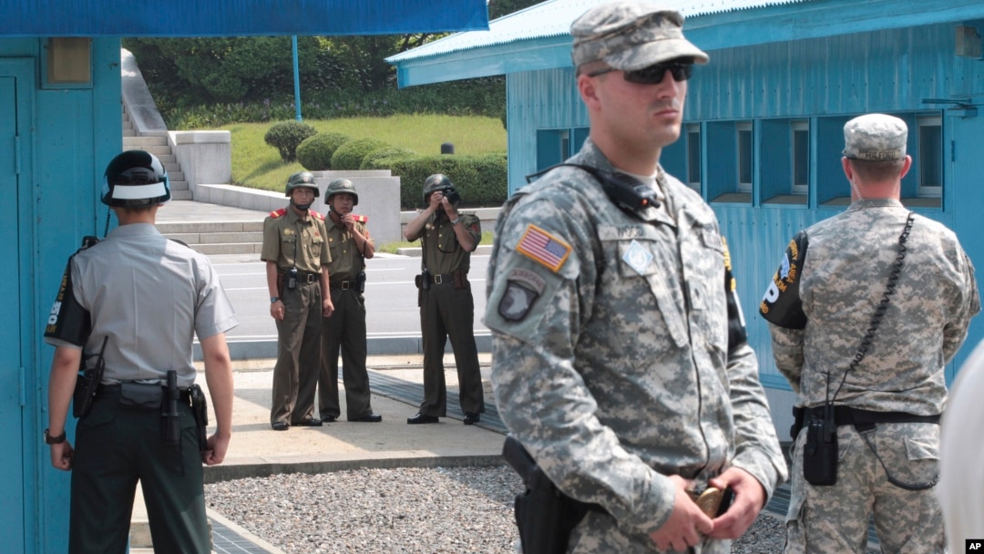 FILE - North Korean army soldiers watch the south side while South Korean, left, and U.S. Army soldiers stand guard at the truce villages of Panmunjom in Paju, South Korea, July 27, 2014.