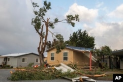 A large tree branch crashed into a garage near Coe Avenue in Seaside, Calif., Saturday, Dec. 14, 2024.