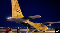 FILE - An Egyptian military plane waiting to take tourists who tested positive for the new coronavirus from Luxor to quarantine facilities on Egypt’s north coast, March 8, 2020.