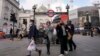 Warga mengenakan masker saat keluar dari stasiun bawah tanah Piccadilly Circus, di London, Selasa, 19 Oktober 2021. (AP Photo/Alberto Pezzali)