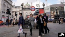 Warga mengenakan masker saat keluar dari stasiun bawah tanah Piccadilly Circus, di London, Selasa, 19 Oktober 2021. (AP Photo/Alberto Pezzali)