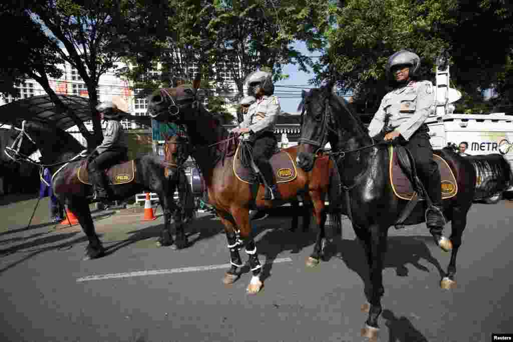 Para polisi menunggang kuda melewati kantor pusat Komisi Pemilihan Umum (KPU) (22/7). (Reuters/Darren Whiteside)