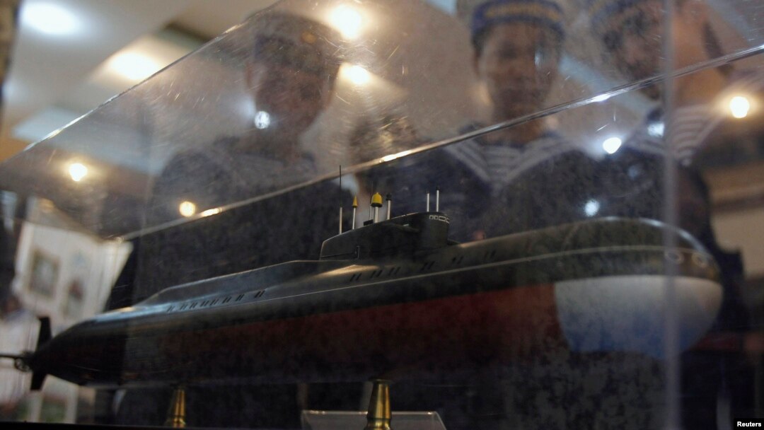 FILE - Sailors look at a model of a submarine at an exhibition as part of the 50th anniversary celebrations of the establishment of the 125 Naval Transport Brigade, also known as the No Number Naval Shipsm, in Vietnam's northern port city of Hai Phong, Oc