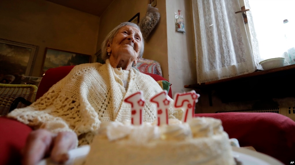 FILE - Emma Morano holds a cake with candles marking 117 years on the day of her birthday, Nov. 29, 2016, in Verbania, Italy. (AP Photo/Antonio Calanni)