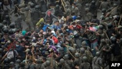 Migrantes hondureños, parte de una caravana que se dirigían a Estados Unidos, se enfrentan con las fuerzas de seguridad guatemaltecas en Vado Hondo, Guatemala, el 17 de enero de 2021. [AFP]