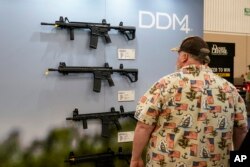 FILE - Guests browse firearms in the Daniel Defense display at the National Rifle Association's Annual Meetings & Exhibits in Indianapolis, Sunday, April 16, 2023.