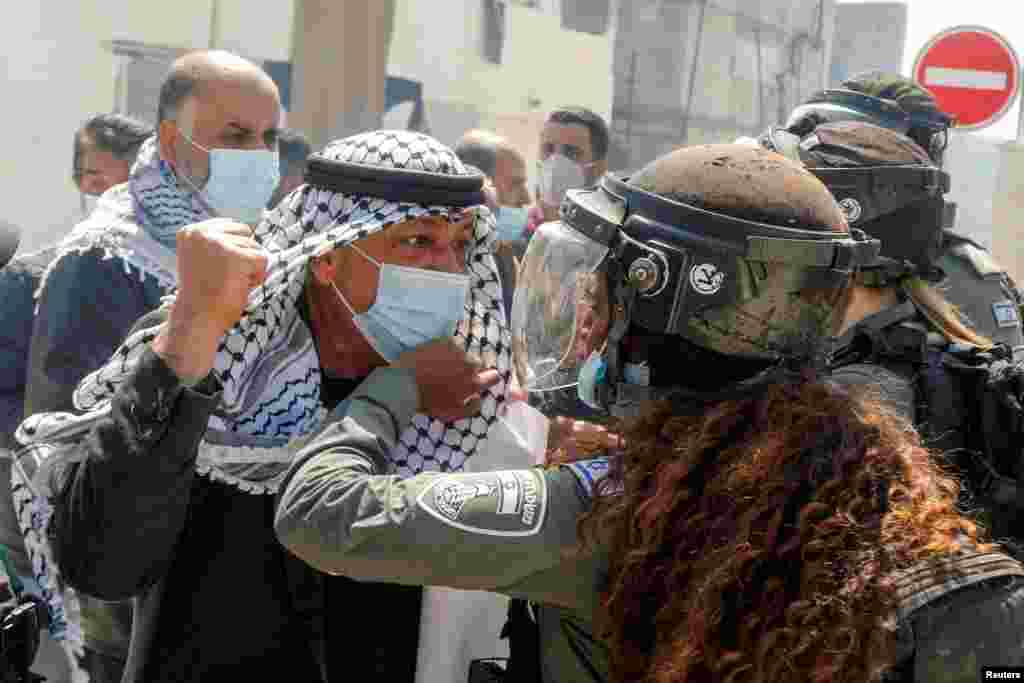 A Palestinian demonstrator scuffles with an Israeli border policewoman during a protest marking &quot;Land Day&quot;, in Sebastia near Nablus, in the Israeli-occupied West Bank.