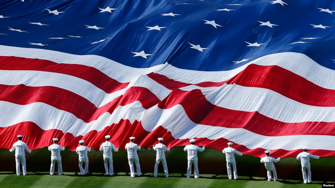 U.S. sailors unravel a huge American flag across the field during opening day ceremonies before the San Diego Padres host the Los Angeles Dodgers in their MLB National League baseball game in San Diego, California, April 9, 2013. 