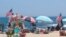 Flags line the beach in Belmar, N.J., as large crowds expected at the Jersey Shore for the July Fourth weekend, some are worried that a failure to heed mask-wearing and social distancing protocols could accelerate the spread of the coronavirus.