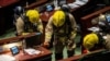 Members of the fire brigade perform tests in the main chamber of the Legislative Council after pan-democrat lawmakers hurled an odorous liquid during the third reading of the national anthem bill in Hong Kong on June 4, 2020.