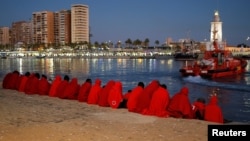 Migrants, part of a group intercepted aboard a dinghy off the coast in the Mediterranean Sea, rest after arriving on a rescue boat at the Port of Malaga, Spain, Dec. 7, 2017. 