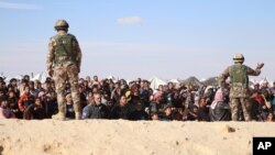 FILE - Syrian refugees wait to be approved to get into Jordan, in the Hadalat reception area, near the northeastern Jordanian border with Syria, and Iraq, near the town of Ruwaished, Jan. 14, 2016.