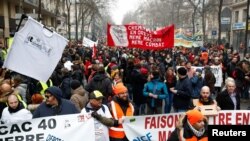 French labor union members and workers on strike attend a demonstration after 24 days of strike against French government's pensions reform plans in Paris, Dec. 28, 2019. 