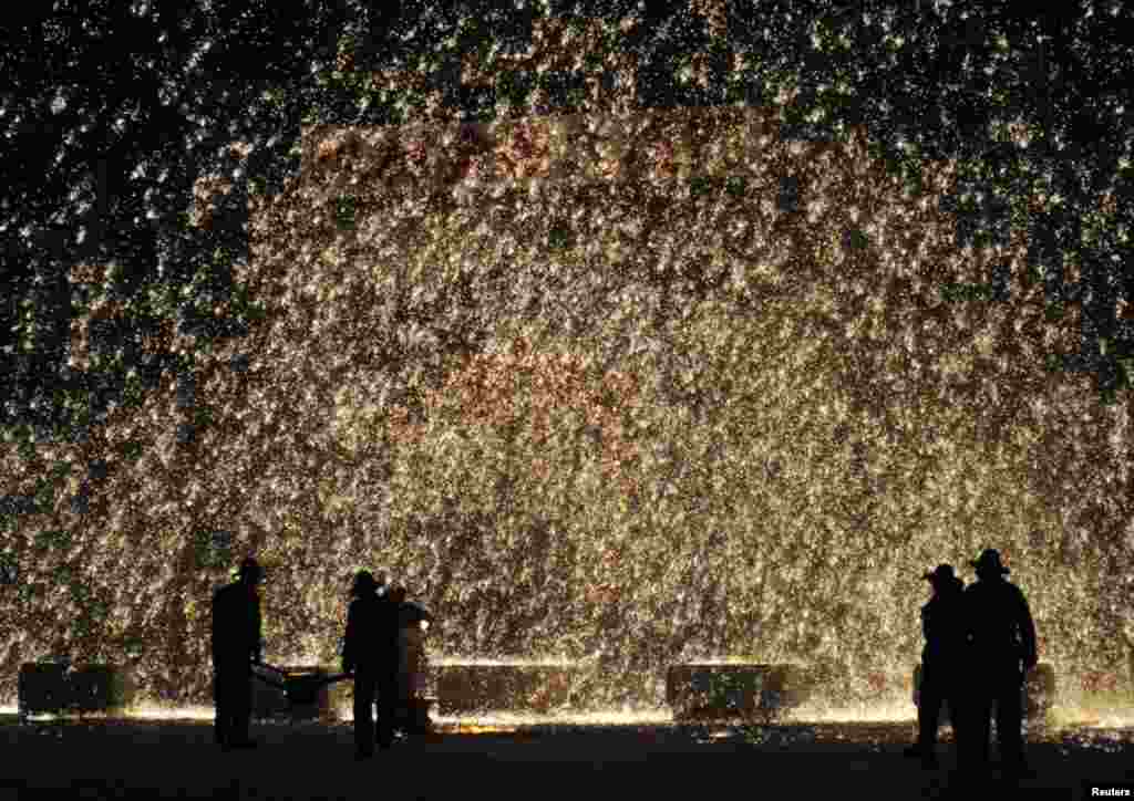 Performers spray molten iron against a concrete wall to celebrate the upcoming Lantern Festival in Nuanquan town of Yuxian County, Hebei province, China, March 1, 2015.