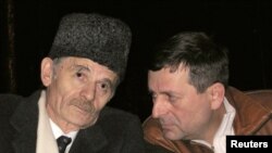 FILE - Crimean Tatar leader Mustafa Dzhemilev (L) speaks to a fellow Tatar in this 2006 photo. 